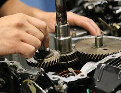 person working on gears in an engine