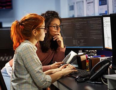 two people working on coding on a computer