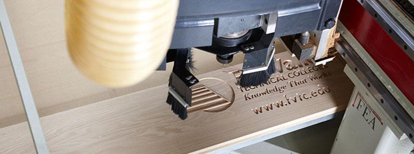 woodworking tool carving the Fox Valley Tech logo onto a piece of wood