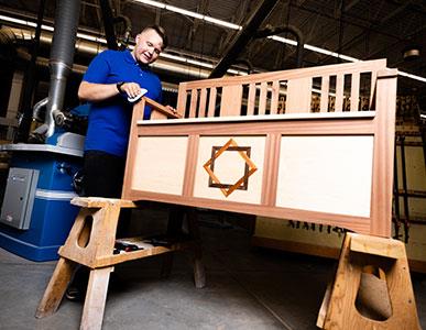 person working on building a bench in woodworking shop