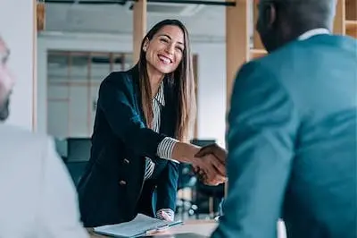 two business people shaking hands across a table