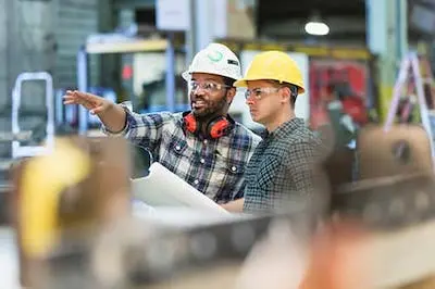 two people in hardhats talking